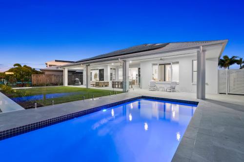 a swimming pool in front of a house at Osprey Oasis in Banksia Beach