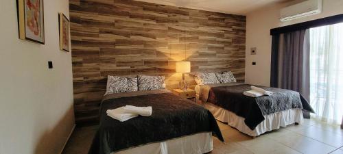two beds in a room with a stone wall at Doña Adelina House in Ciudad Valles
