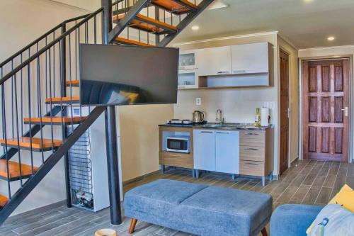 a living room with a staircase and a kitchen at City Views Spacious Mezzanine Apartments in Willemstad