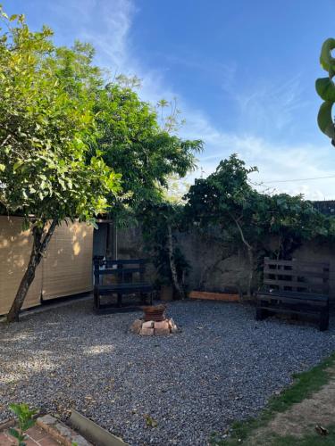 a gravel yard with two benches and a tree at El mochilero in Cartago