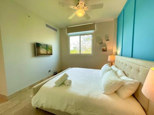 - une chambre avec un grand lit blanc et une fenêtre dans l'établissement Modern - Marina View Balcony - Exquisite Pool - Sleeps 6, à Boca de Río Hato