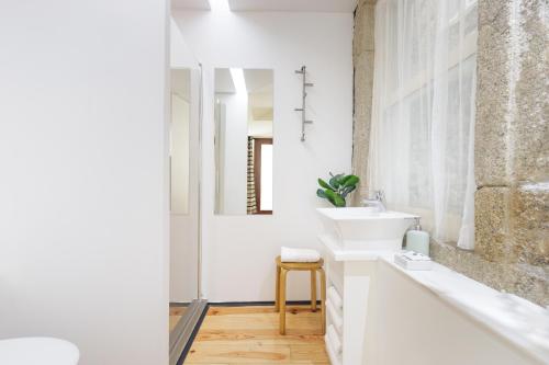 a white bathroom with a sink and a mirror at OX Apartments B Places in Porto