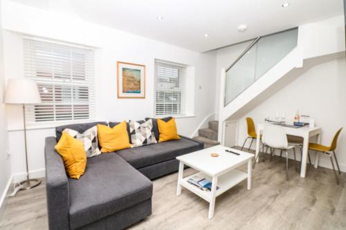 a living room with a couch and a table at Sea Thrift in Teignmouth