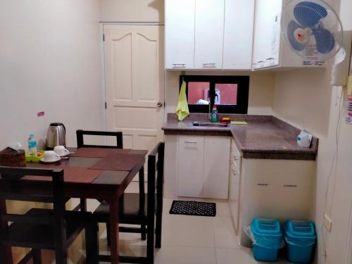a small kitchen with a wooden table and a dining room at V.F. Riton Apartelle in Laoag