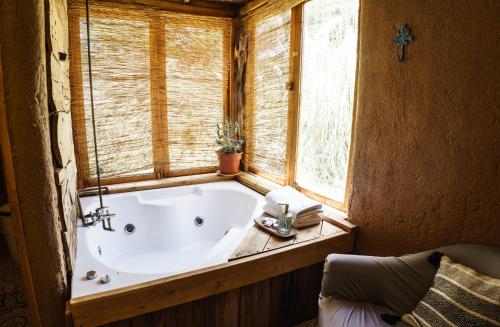 a bath tub in a room with a window at EcoCasa Sutar in San Pedro de Atacama