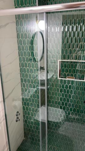 baño con ducha y puerta de cristal en Iluminada Haus en Buenos Aires