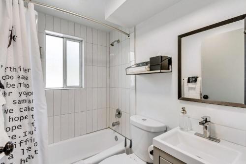 een badkamer met een wastafel, een toilet en een spiegel bij Cozy for Bookworms - Laundry - King Bed - Parking in Salt Lake City