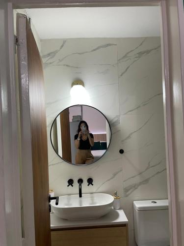 Eine Frau macht ein Foto im Badezimmerspiegel in der Unterkunft Iluminada Haus in Buenos Aires