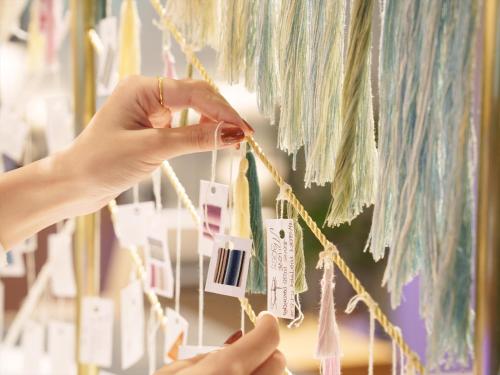 a person is holding a piece of paper on a string at CROSS Life Hakata Yanagibashi in Fukuoka