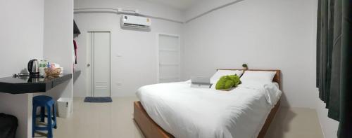 a bedroom with a bed with a green stuffed animal on it at ซีนายเฮ้าส์ Z9 House in Ban Kao