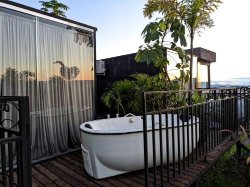 a bath tub sitting on top of a balcony at Tiny House Paraiso Minicasas Com Hidromassagem in Pouso Alegre