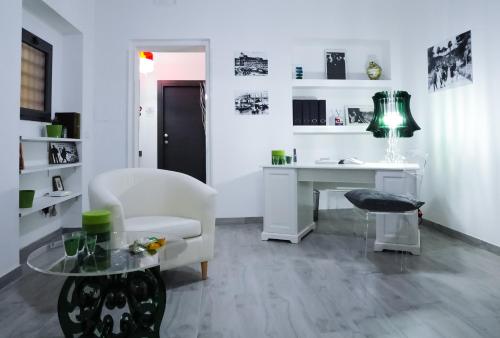 a white living room with a desk and a chair at Etna Suite Group in Catania