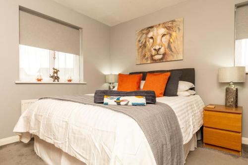 a bedroom with a bed with orange pillows and a lion painting at iStay Here Ltd - 1 Bed House with Wifi and Parking - An African Adventure in Aston End