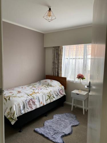 um quarto com uma cama e uma janela em Home away from home air b and b em Whangarei