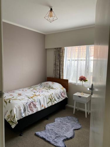 a bedroom with a bed and a window at Home away from home air b and b in Whangarei