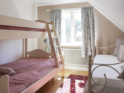 a childs bedroom with bunk beds and a window at Holiday home HÄLLEVADSHOLM II in Hällevadsholm