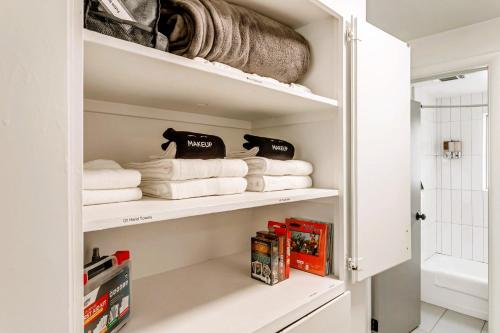 uma casa de banho com toalhas brancas e livros nas prateleiras em Convenient - Near Hospitals - King Bed em Salt Lake City