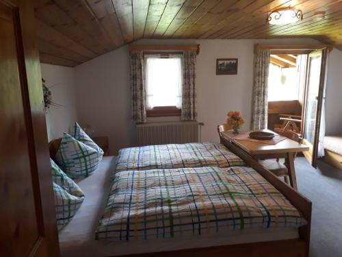 a bedroom with a large bed and a table at Haus Widlbrand in Schönau am Königssee