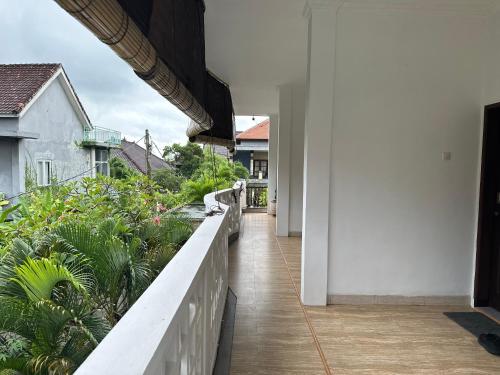 a balcony of a house with plants at Koming Guest House in Canggu