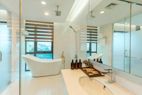 La salle de bains blanche est pourvue d'une baignoire et d'un lavabo. dans l'établissement MT Collection Hotel, à Ninh Binh