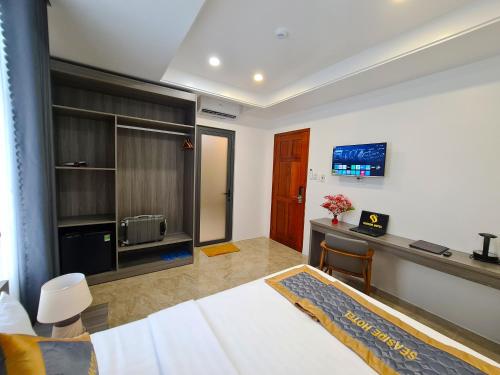 a bedroom with a bed and a desk and a television at Seaside Hotel - Rach Gia in Rach Gia