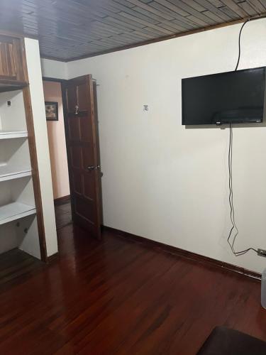 a living room with a flat screen tv on a wall at El mochilero in Cartago