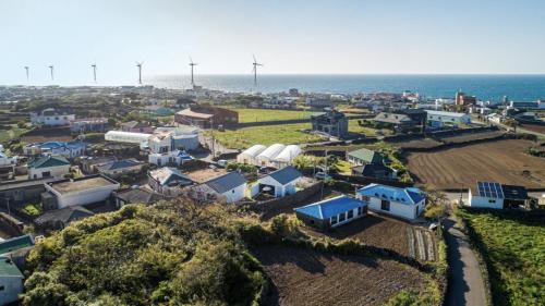 an aerial view of a small town with the ocean at Panpo HyunStay in Jeju