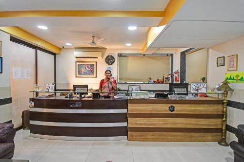 a woman standing at the counter of a restaurant at Townhouse Hotel The Platinum in Pātipukur