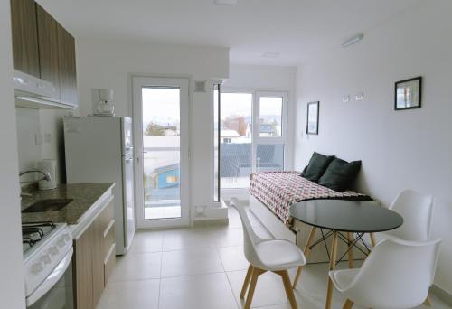 cocina blanca con mesa, mesa y sillas en Altos de Cervantes, en Ushuaia