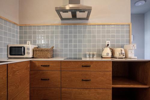 a kitchen with a counter top with a microwave at Panpo HyunStay in Jeju