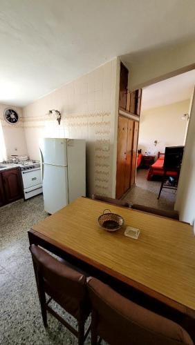 cocina con mesa de madera y nevera en Departamento en Termas de Río Hondo