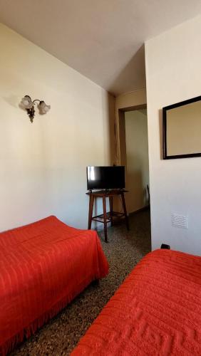 Habitación con 2 camas y escritorio con TV. en Departamento en Termas de Río Hondo
