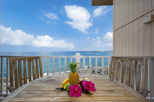 a pineapple sitting on a wooden table on the beach at Ocean Front Condo SV4207 in Kailua-Kona