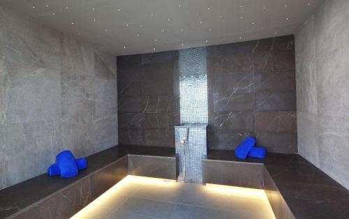 a bathroom with a tub with blue chairs in it at JS Palma Stay - Adults Only in Can Pastilla
