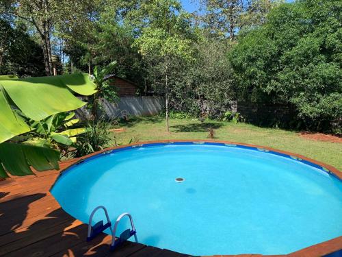 een groot blauw zwembad in een tuin bij Los Bananos - Big Wood Cabin in Puerto Iguazú