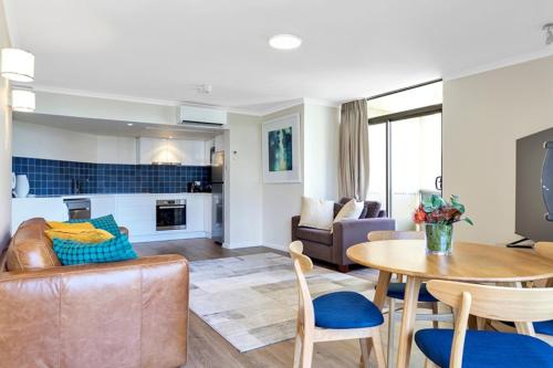 een woonkamer met een bank en een tafel bij Apartment on Top of the Park in Sydney