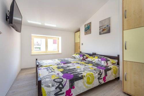 a bedroom with a bed with a colorful comforter at Villa Villetta Valtura in Ližnjan