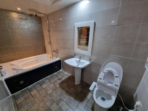 uma casa de banho com uma banheira, um WC e um lavatório. em Fox Motel em Daegu