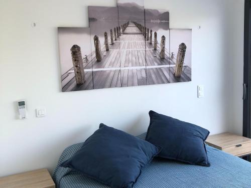 une chambre avec un lit avec un tableau sur le mur dans l'établissement Row House in Corsica near Canella Beach, à Favone