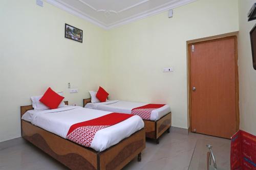 1 dormitorio con 2 camas y almohadas rojas en OYO Hotel Kanako International, en Bodh Gaya