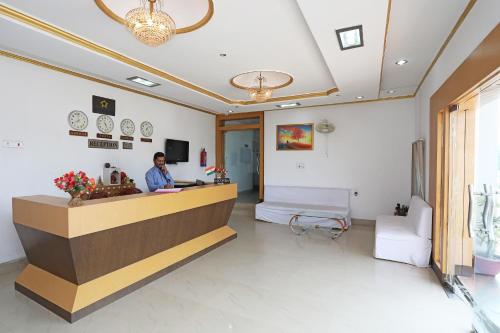 a man standing at a reception desk in a hospital lobby at OYO Hotel Kanako International in Bodh Gaya