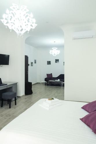 a bedroom with a bed and a living room at Etna Suite Group in Catania