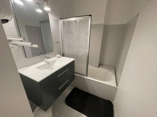 uma casa de banho com um lavatório, um chuveiro e uma banheira em Appartement Vallon-Pont-d'Arc, 3 pièces, 4 personnes - FR-1-697-20 em Vallon-Pont-dʼArc