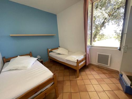 Duas camas num pequeno quarto com uma janela em Appartement Vallon-Pont-d'Arc, 3 pièces, 4 personnes - FR-1-697-20 em Vallon-Pont-dʼArc