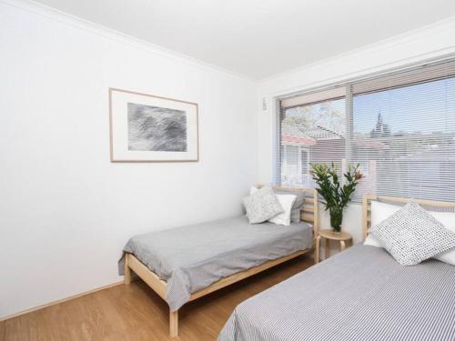 a bedroom with two beds and a window at BOT01 - Balmoral Light and Airy Beach Apartment in Sydney