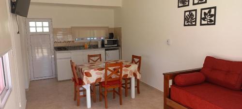 eine Küche mit einem Esstisch und einem roten Sofa in der Unterkunft B&Z Departamentos in Federación