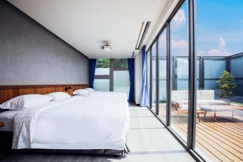 a bedroom with a large bed and a balcony at Hotel BEGINS 倉箱蜜境文旅 in Keelung