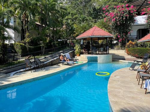 a person sitting in a chair next to a swimming pool at The Scarlet Villas in Ojochal