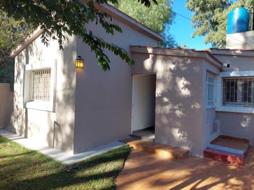 una casa blanca con una puerta y un patio en Sol y Monte en Capilla del Monte