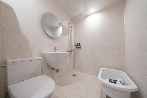 a white bathroom with a toilet and a sink at Aank Hotel Daejeon Yuseong 2nd in Daejeon